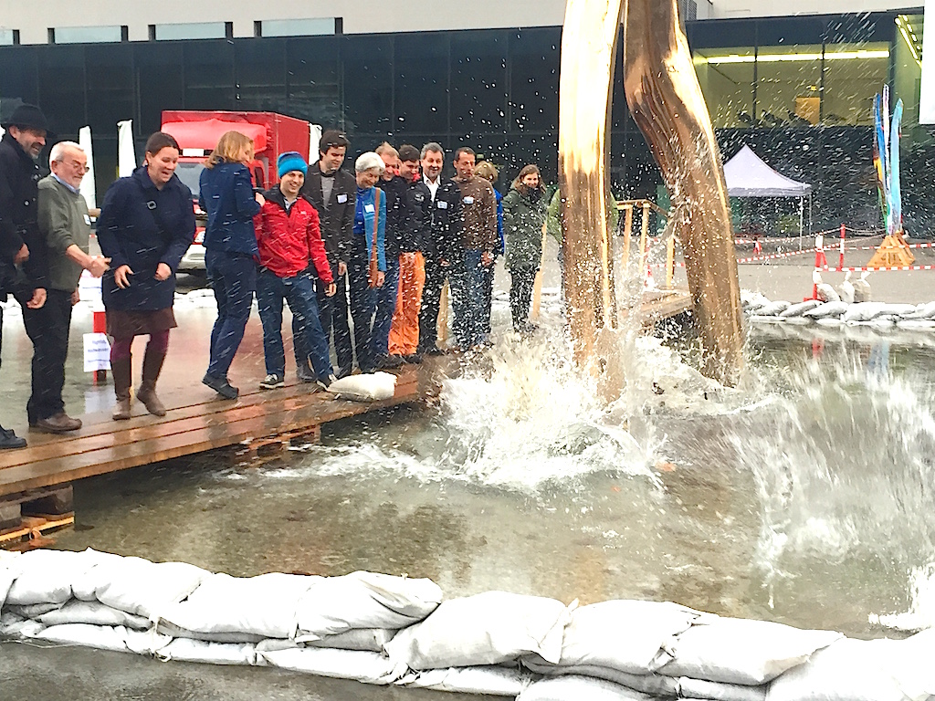 Hochwasser-Simulation vor dem Festspielhaus, VertreterInnen der Trägerorganisationen auf der Brücke über dem "Hochwasser"