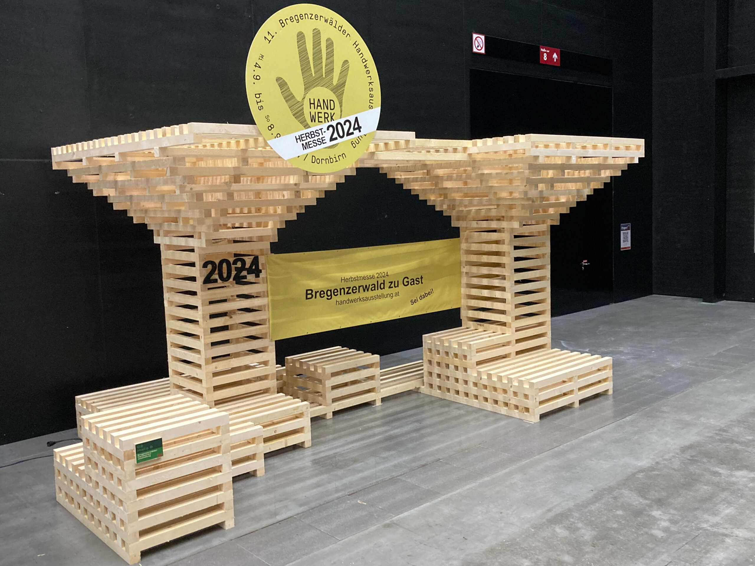 Ausstellungsstück Herbstmesse 2023: zwei stilisierte Bäume mit Sitzgelegenheiten, zusammengesetzt aus heimischem, wiederverwendbarem Bau-Holz, in einer Dimension